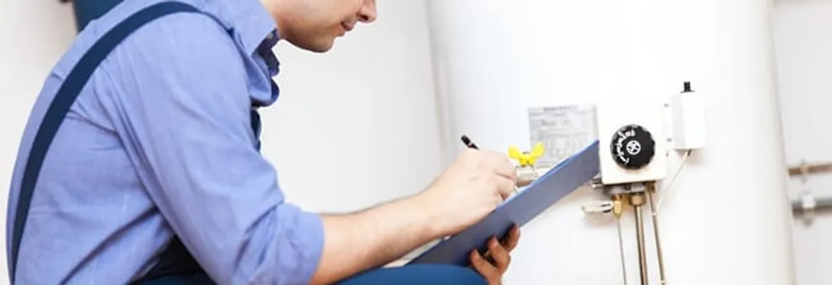 Water heater repair technician inspecting the unit and recording service notes in Anchorage, AK